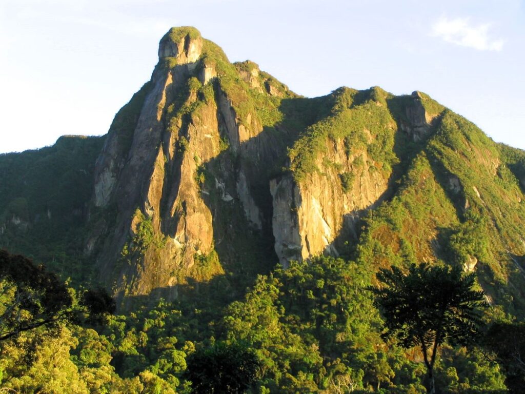 Huge cliffy peak draped with lush, green vegetation