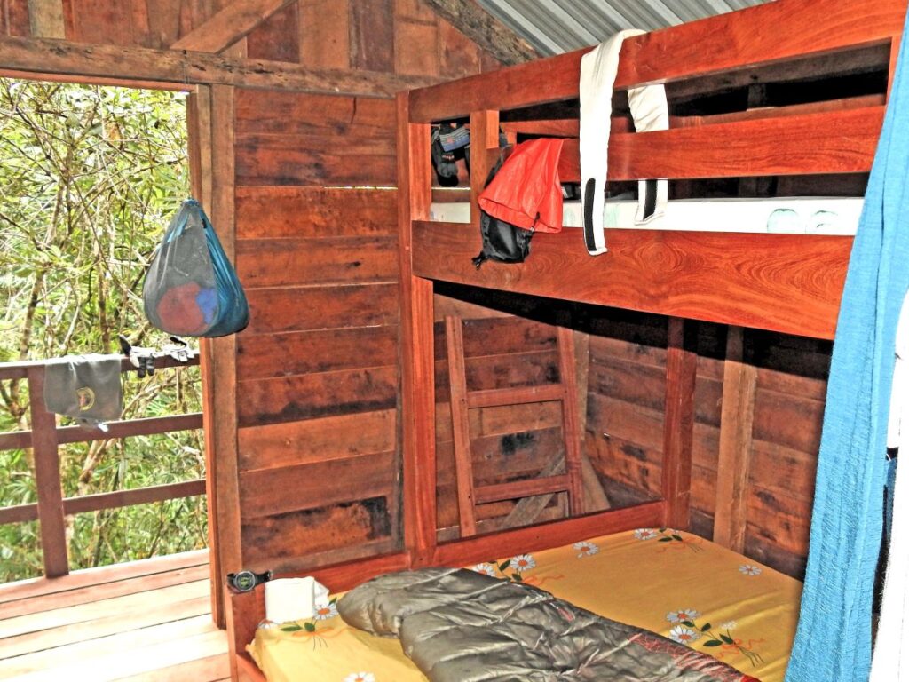 Wooden bunk beds inside a small wooden cabin.